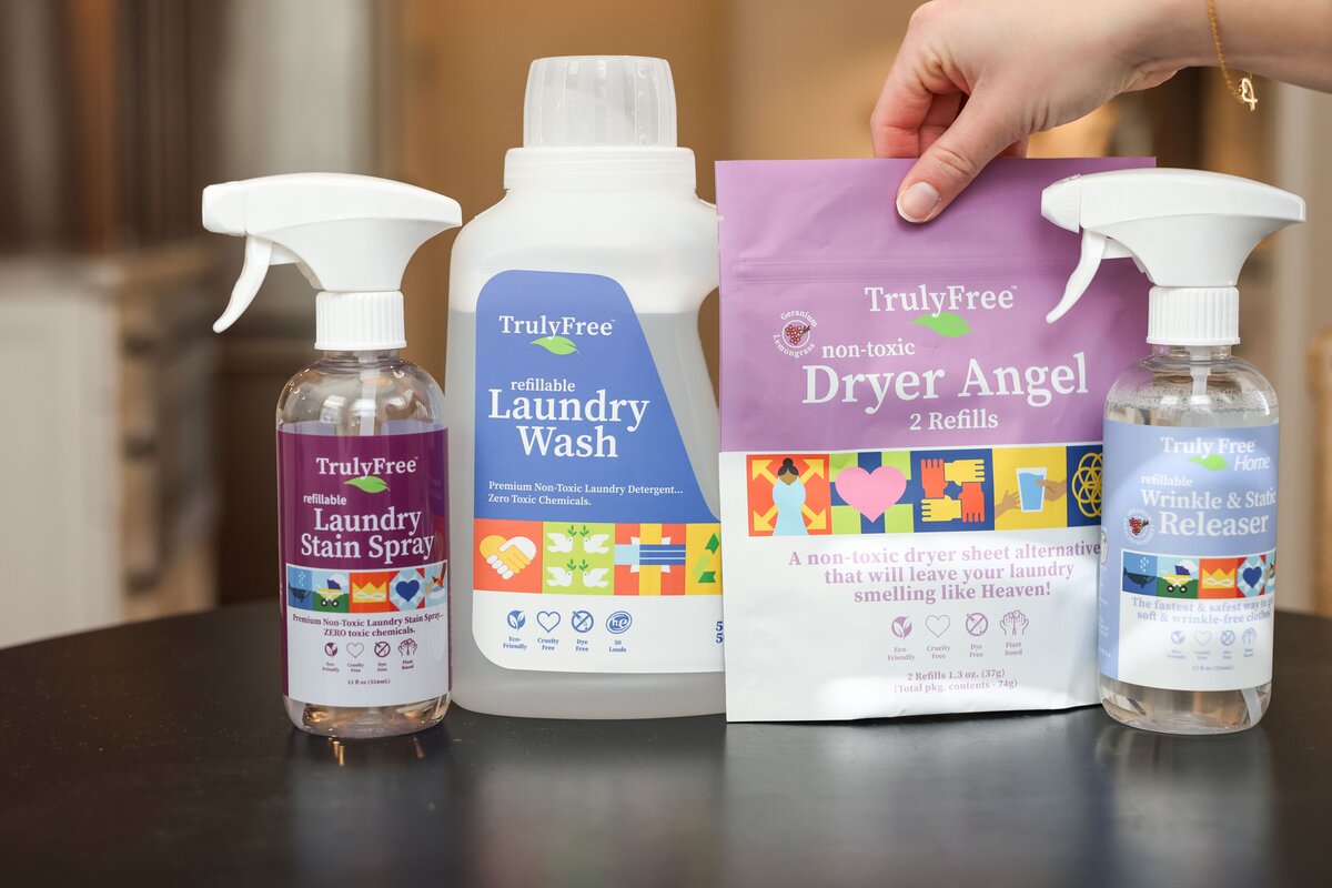 Line up of Truly Free Home non-toxic cleaning products - Laundry stain spray, refillable laundry wash, non-toxic dryer angel, wrinkle & static releaser