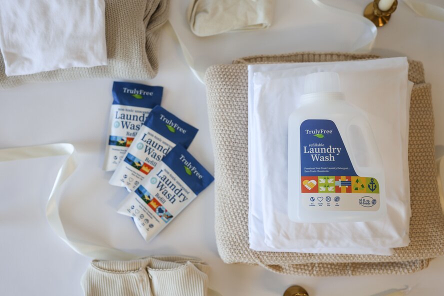 Truly Free Home Laundry Wash jug on a stack of folded clothes.