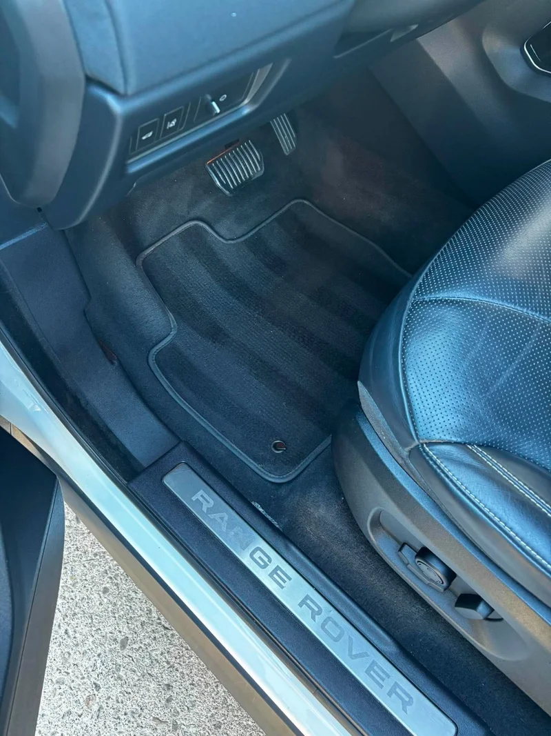 Clean driver-side carpet and fitted floor mat after detailing
