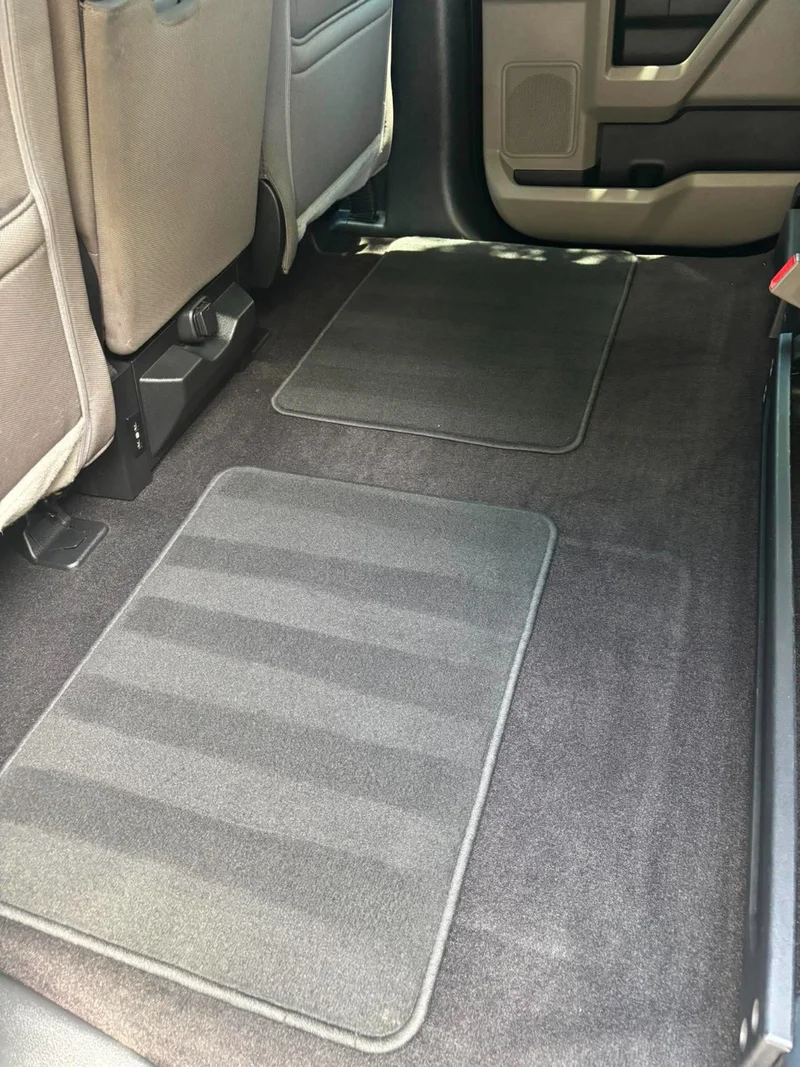 Detailed performance vehicle driver footwell with a clean branded floor mat