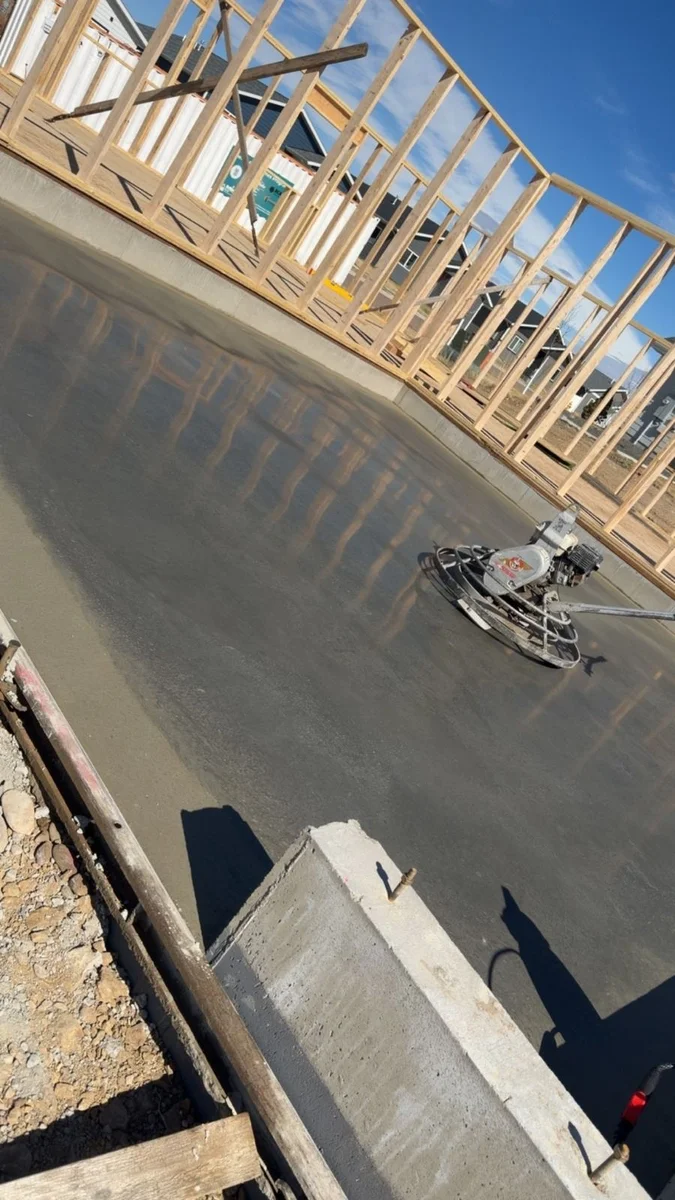 Concrete being screeded and finished on a fresh pour