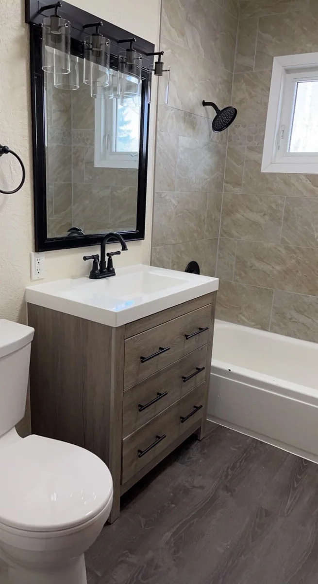 Completed bathroom remodel with new vanity, tile surround, and modern fixtures