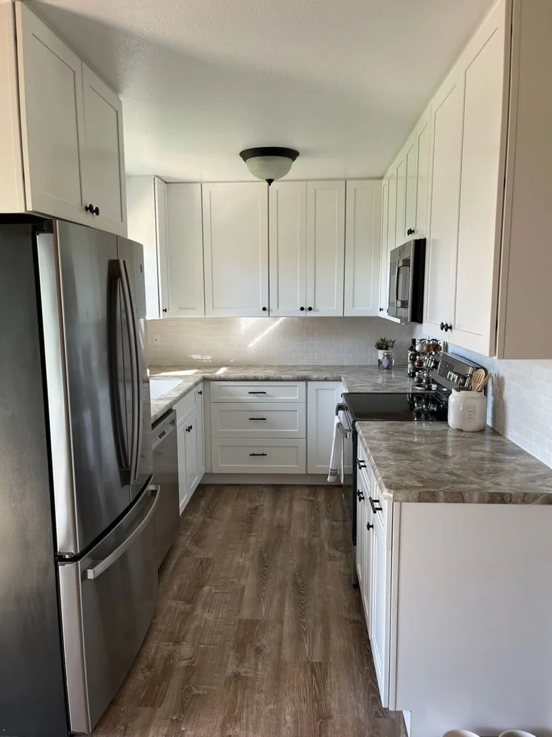Completed kitchen remodel with white cabinetry and new countertops
