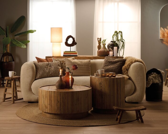 Dagligstue indrettet i boho stil med rustikke træmøbler i massivt fyrretræ, sammensat med en lys beige sofa og interiør i jordfarver der passer boho stilen.