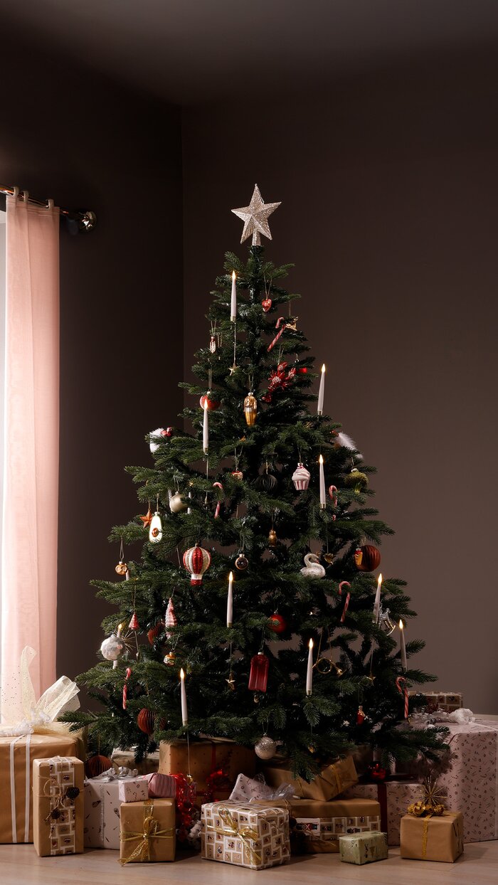 Juletræ med julepynt og gaver under i en stue