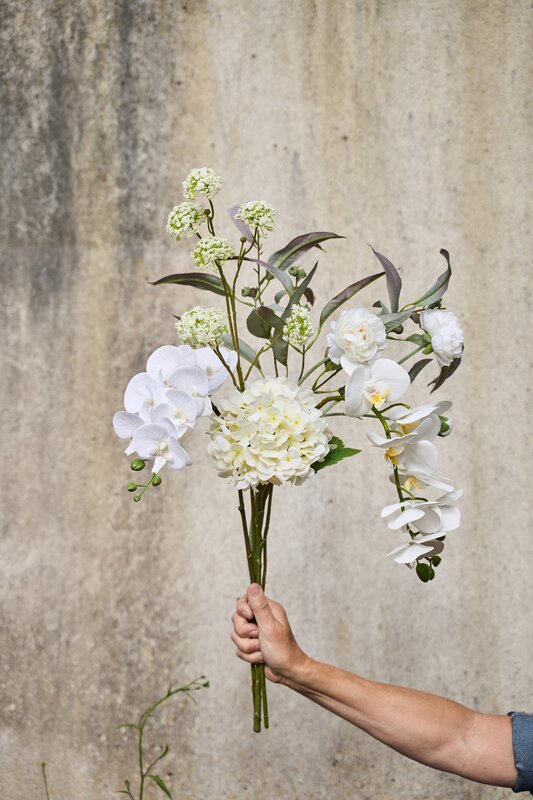 Atlas stentøjstel i sand, rosa og hvidt vist på et træbord med mad og dekoration