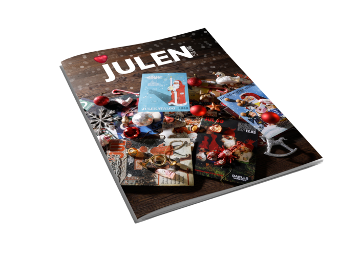 Magasin med titlen “JULEN” på forsiden, omgivet af julepynt, kugler og gamle julemotiver på et træbord.