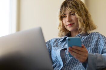 Ung kvinde betaler online med Klarna betalingsløsning via laptop og mobil