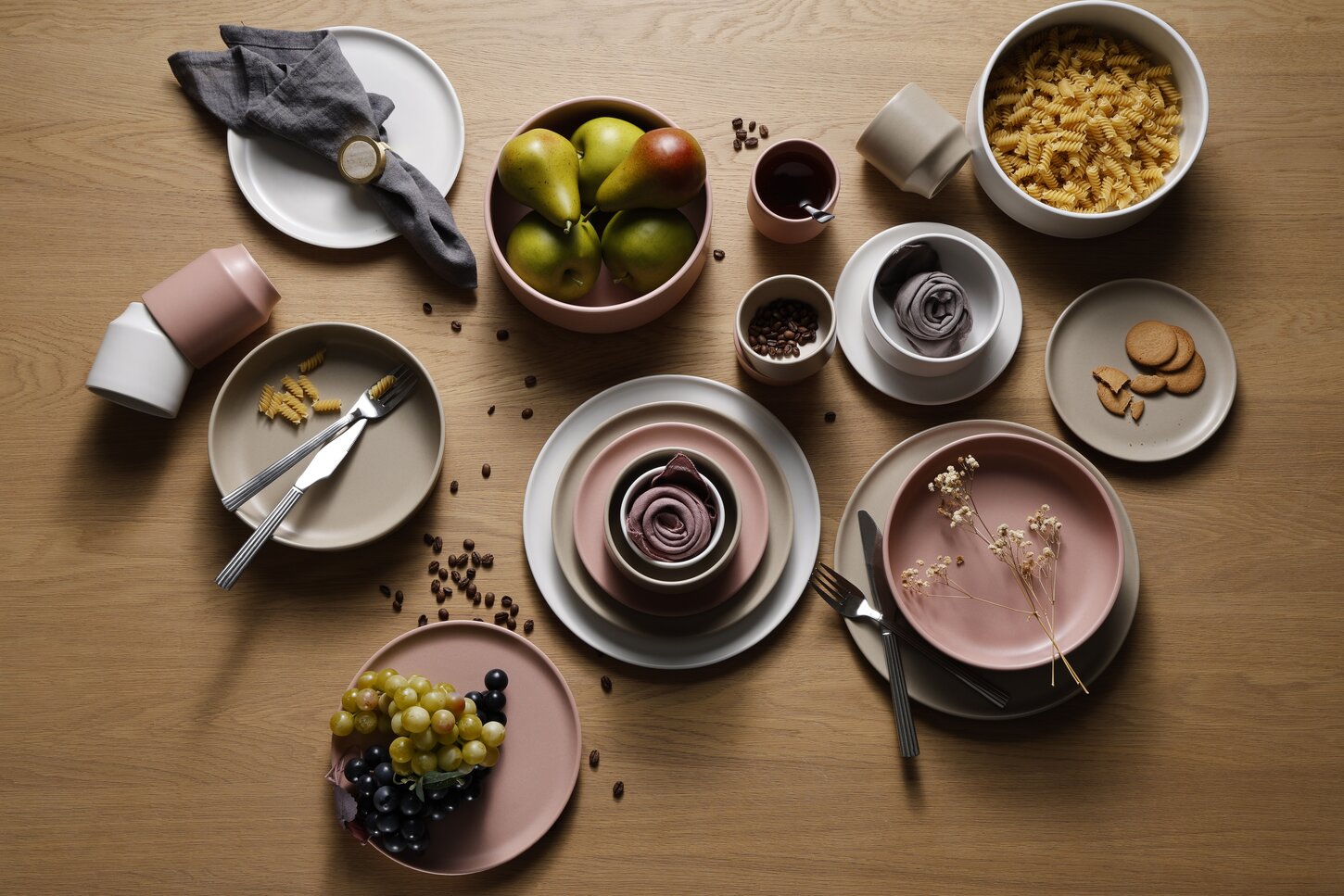 Atlas stentøjstel i sand, rosa og hvidt vist på et træbord med mad og dekoration