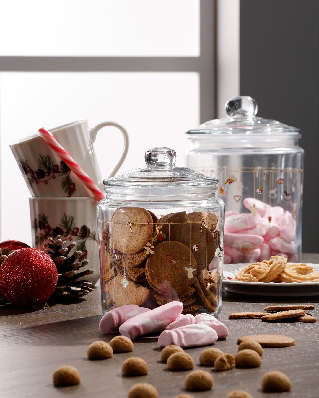 Bord med glaskrukker med småkager og juleskum, sammen med to julekopper