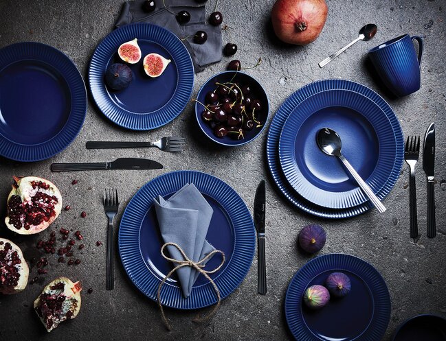 Elegant borddækning med mørkeblåt stel, sort bestik og friske frugter som pynt – stilren og moderne inspiration fra Daells Bolighus.