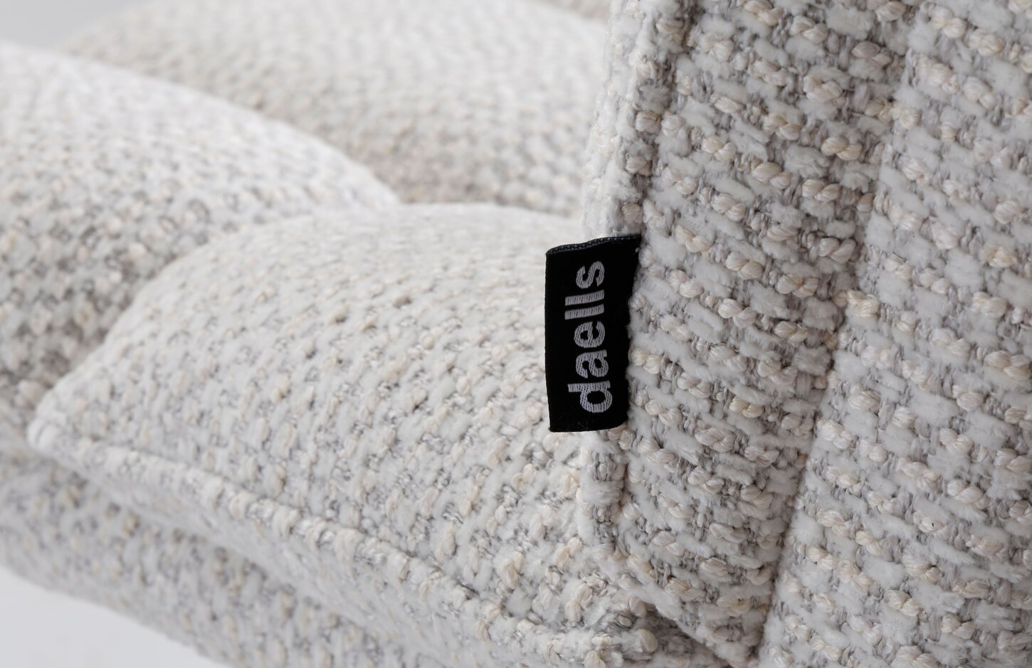 Close-up af daells private label logo på kanten af en beige farvet spisebordsstol