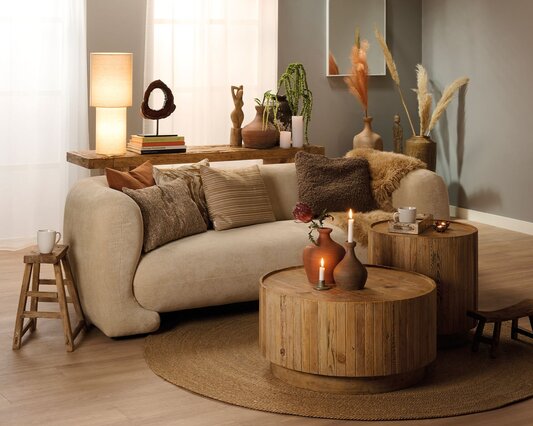 Dagligstue indrettet i boho stil med beige sofa og runde rustikke sofaborde.