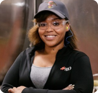 Woman standing in front of a metal beer brewery tank