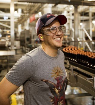 Man standing in front of assembly line for Budweiser bottles