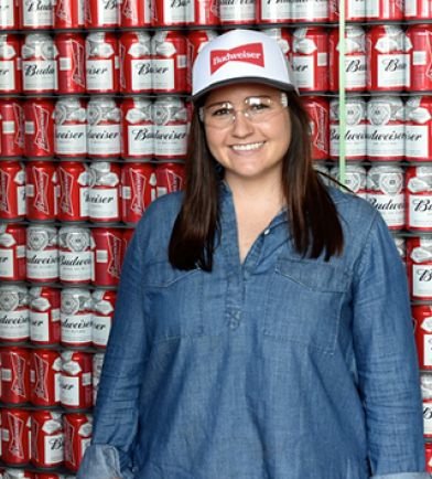 Woman standing in front of a pallet of Budweiser cans