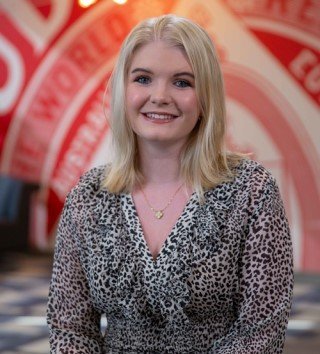 Woman standing in front of a pallet of Budweiser cans