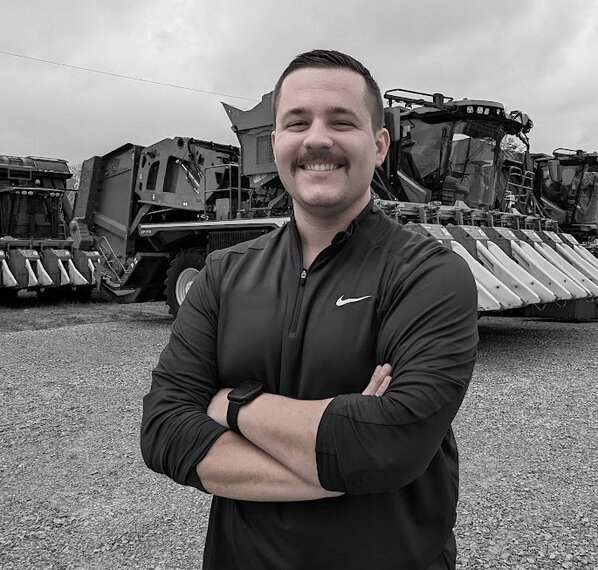 man standing in front of combine harvesters