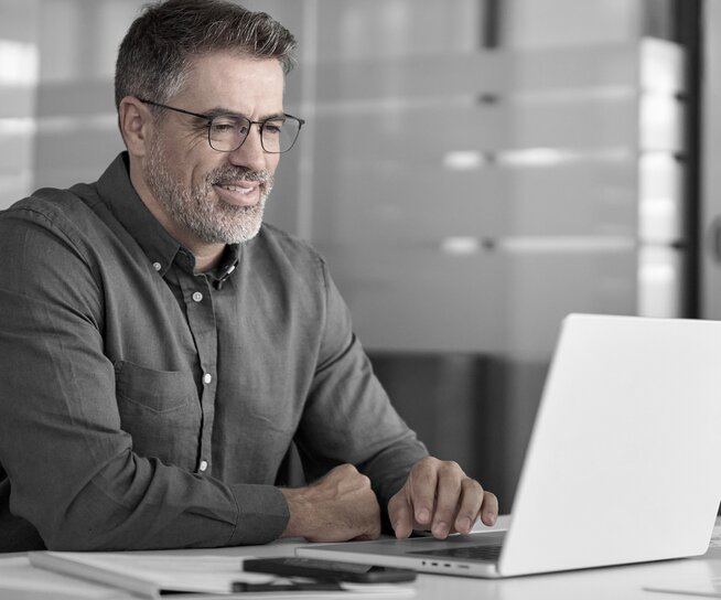 man in office looking at laptop