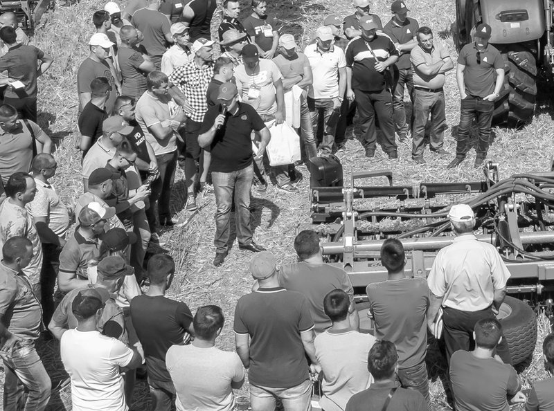 buyers standing around equipment at auction