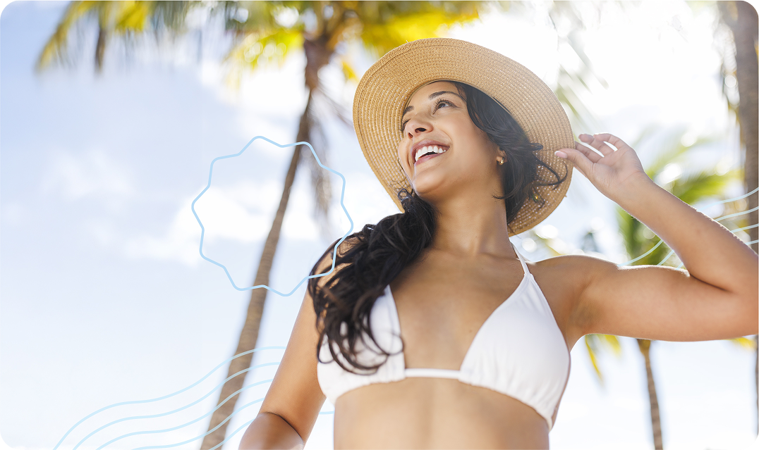 Happy woman in a swimsuit wearing a hat and bikini smiling and looking up after getting laser hair removal at her local Milan Laser clinic
