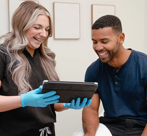 Man in a blue shirt smiling at a bodybuilding laser hair removal treatment consultation
