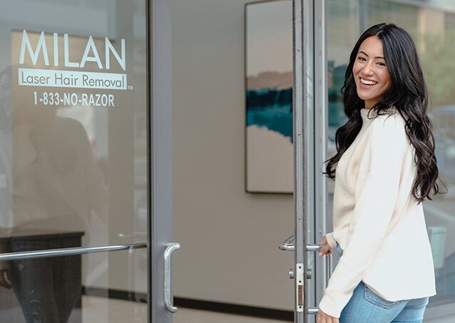 A woman wearing a white top and blue jeans enters a Milan Laser clinic for a laser hair removal appointment for a blog titled How To Choose A Laser Hair Removal Clinic.