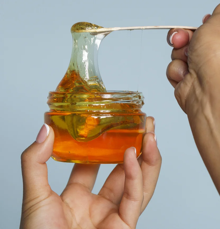 Image of a person pulling up wax from a jar in preparation for laser hair removal