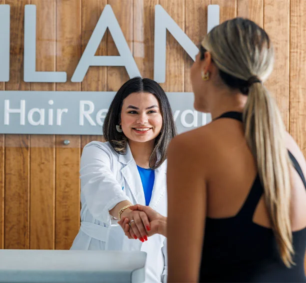 People shaking hands in a Milan clinic in preparation for stomach laser hair removal