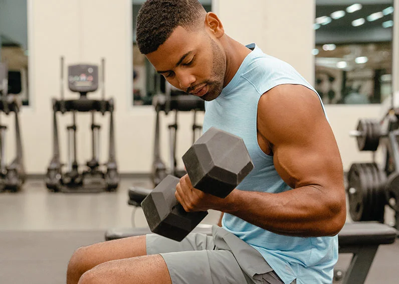 Man doing arm curls in a gym