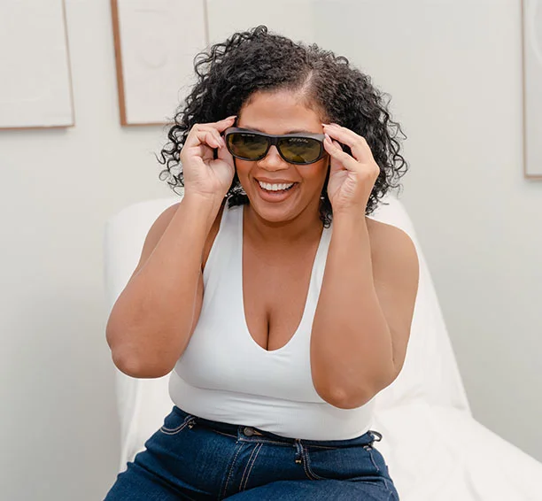 Smiling woman in a white shirt who just got laser hair removal on her chin