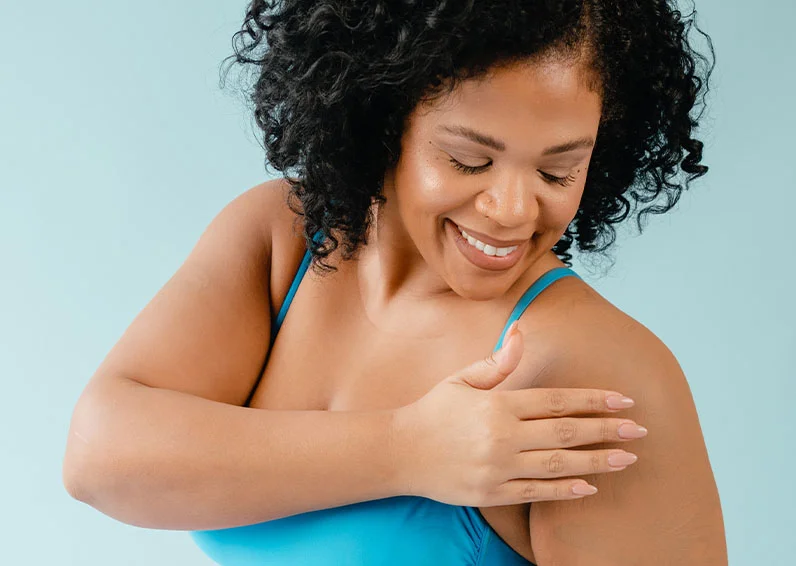 Smiling woman excitedly showing off her recently-lasered hands and looking to her left