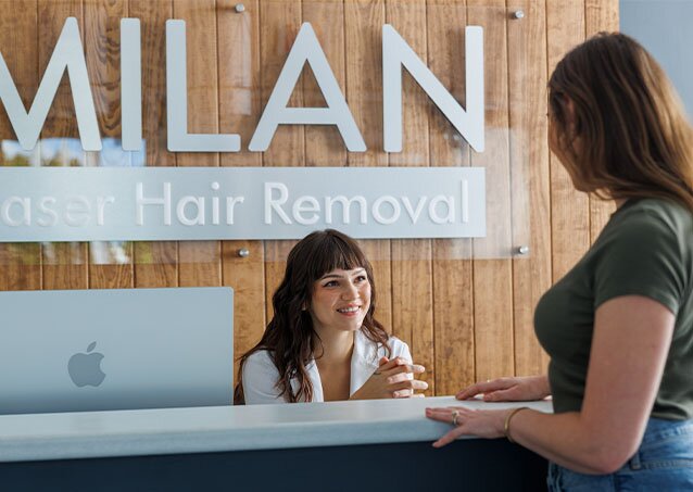 Close-up of a woman going to a Milan Laser Hair Removal clinic and talking to the receptionist
