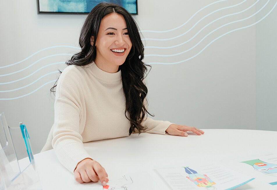 Woman with dark hair pointing to something on a table during a Milan consultation in a white room as part of the about us page timeline
