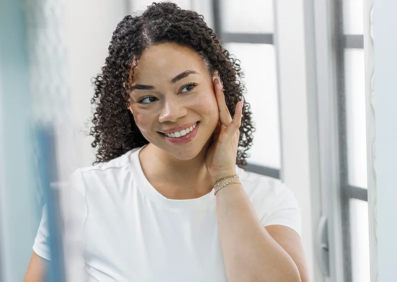 Man holding his shoulder and smiling because he just got neck laser hair removal