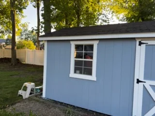 Blue painted shed with white trim and doors