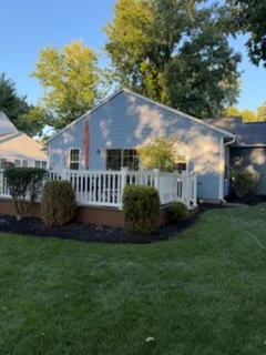 Painted home porch with white siding and dark green shutters