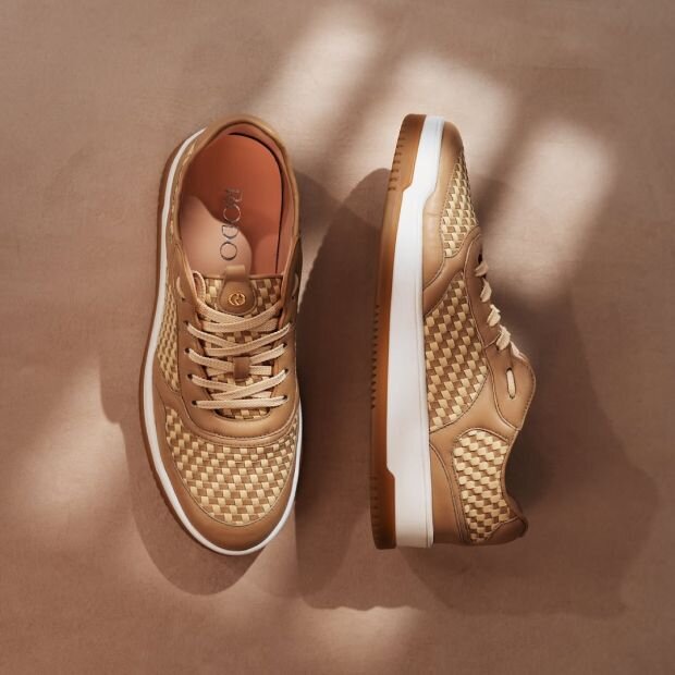 A pair of sneakers with a two-tone woven leather exterior and rounded toe.