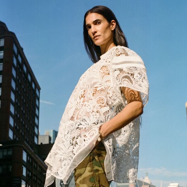 A women wearing a white lacy blouse with puff sleeves.