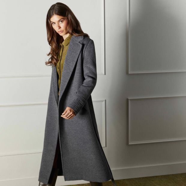 A model wearing a grey wool maxi-length coat with a lapel collar.