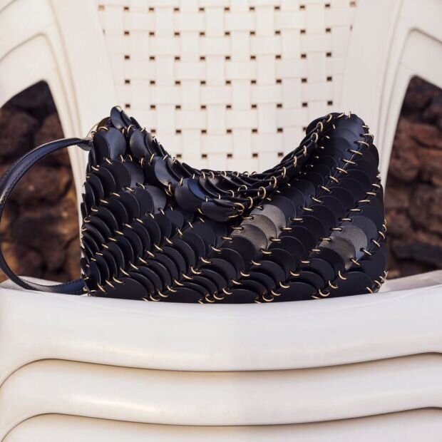 A blue leather paillette shoulder bag with discs bonded together by smaller gold metal rings.
