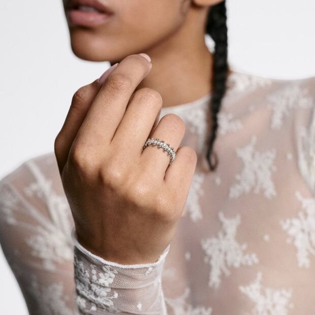 A model wearing a white gold beaded ring with round-cut diamonds.
