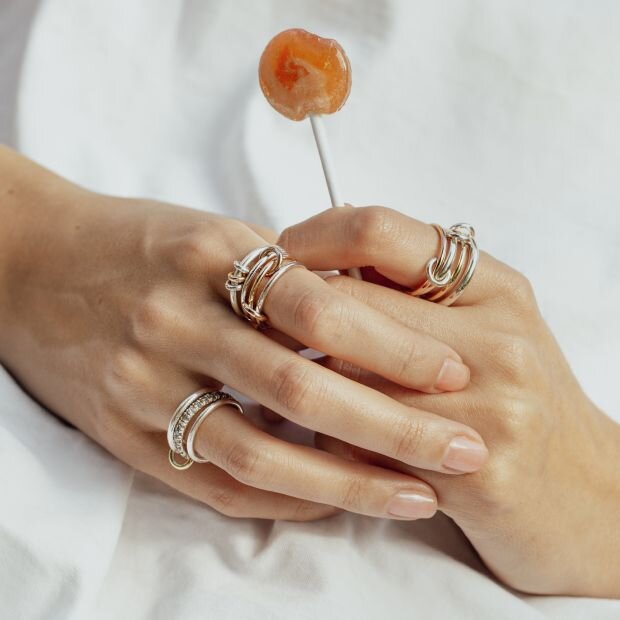 A model wearing multiple yellow and white gold two-tone diamond linked rings.