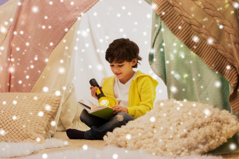 young boy sitting on ground reading book