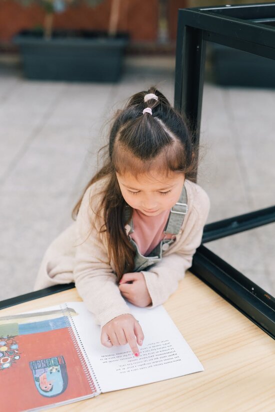 Girl sitting at school desk reading a book
