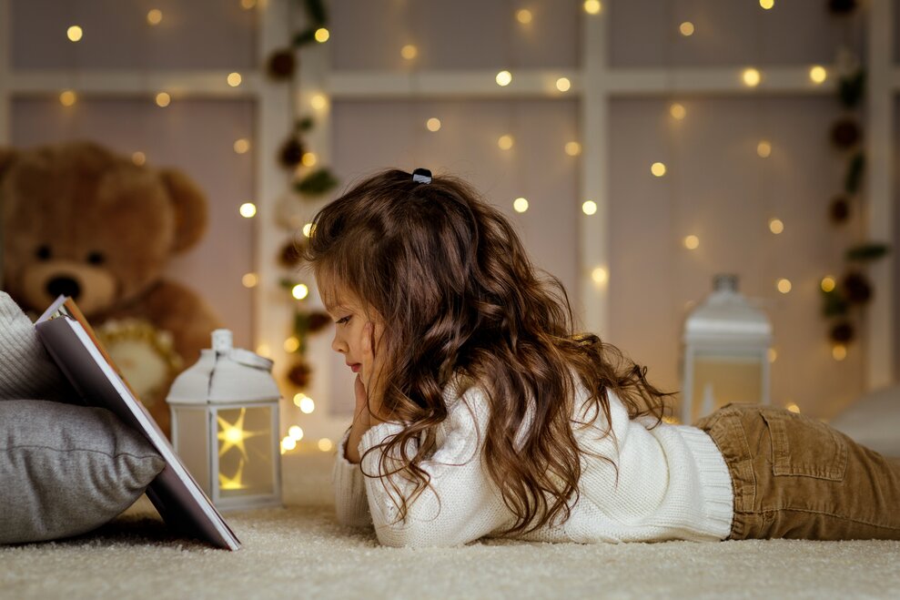 toddler laying on ground reading a book