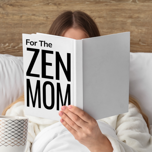 Woman holding up book in front of face that says: "For the Zen Mom"