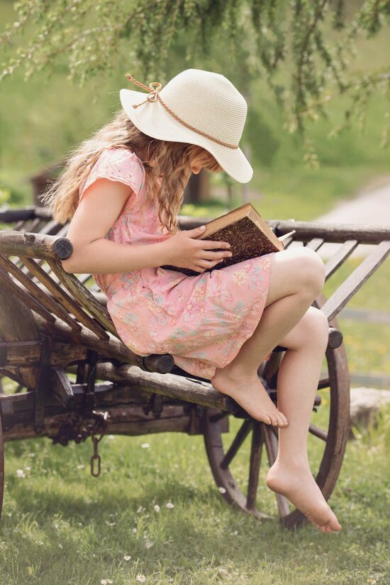 Girl sitting outisde reading a book