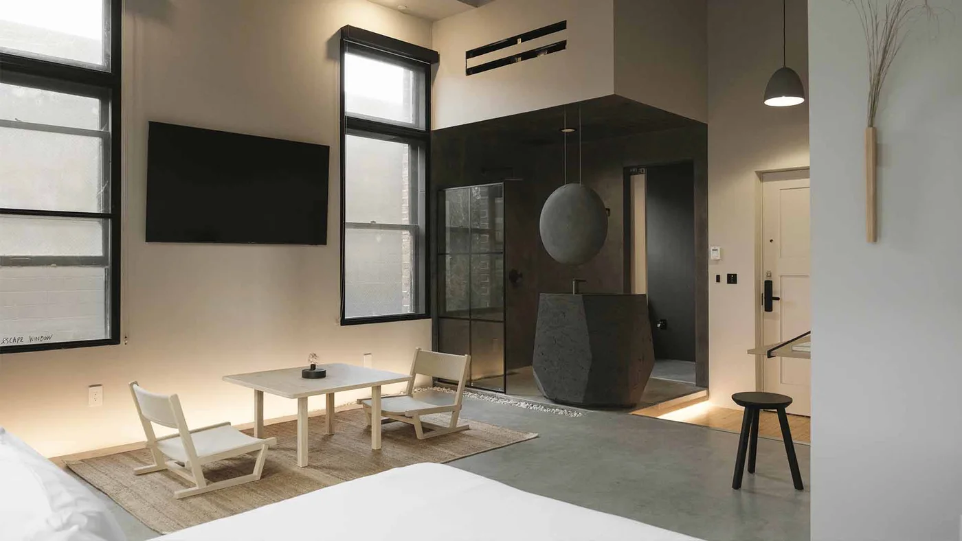 Design hotel room with a lounge area and stone bathtub