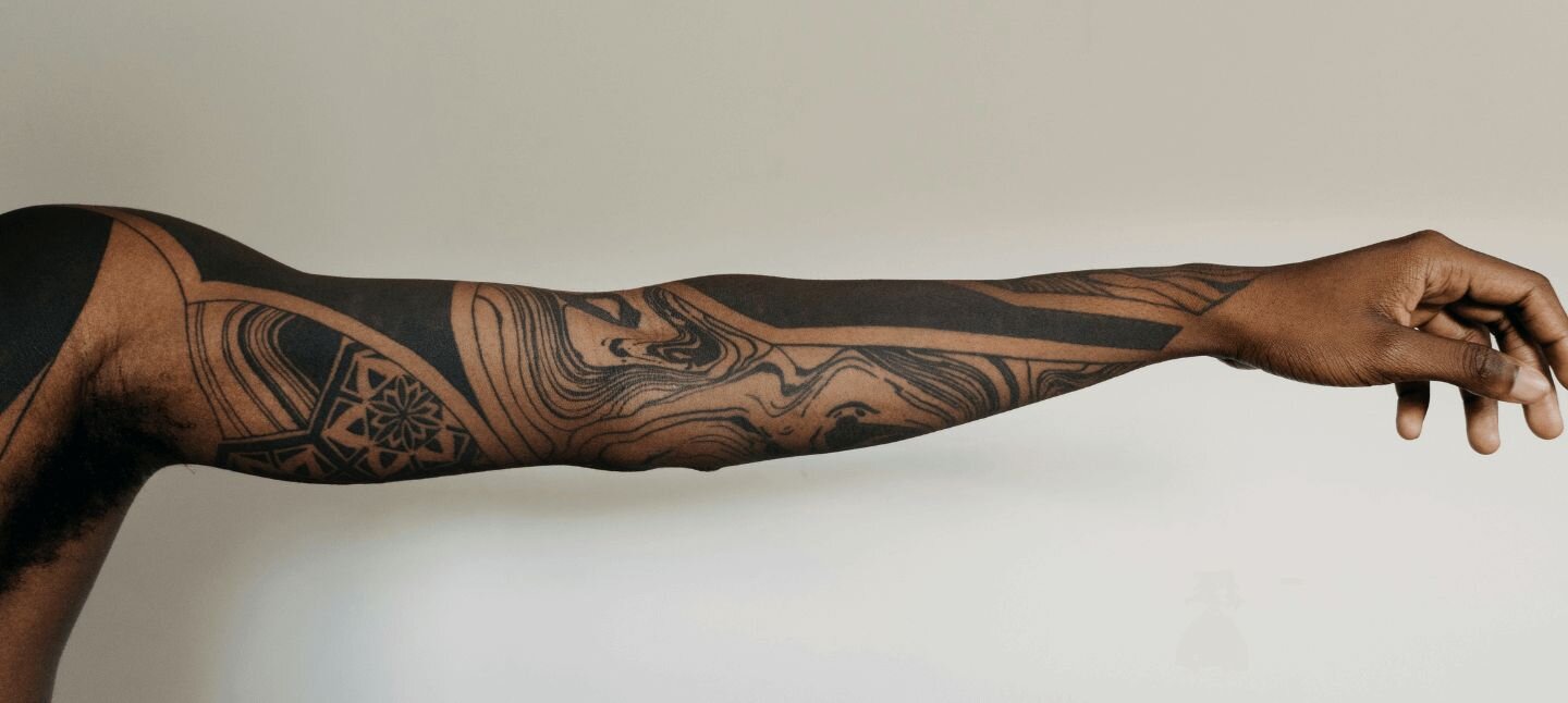 Tattoo Artist taking a photo of a tattoo on a client